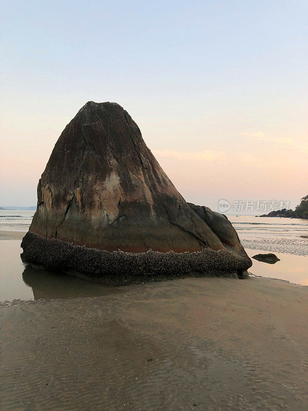 在印度果阿海滩，海边的日落和巨大的海滩岩石的映像，Palolem海滩度假与退潮，显示海岸线湿沙涟漪和岩石/潮汐池在退潮，岩石巨石和在果阿的冬季度假照片